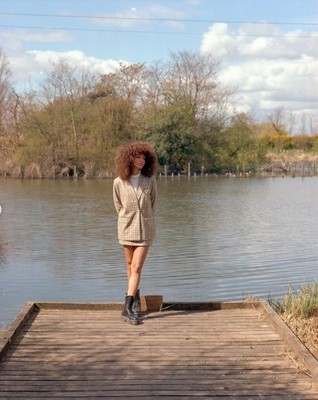 a woman standing on a dock next to a body of water