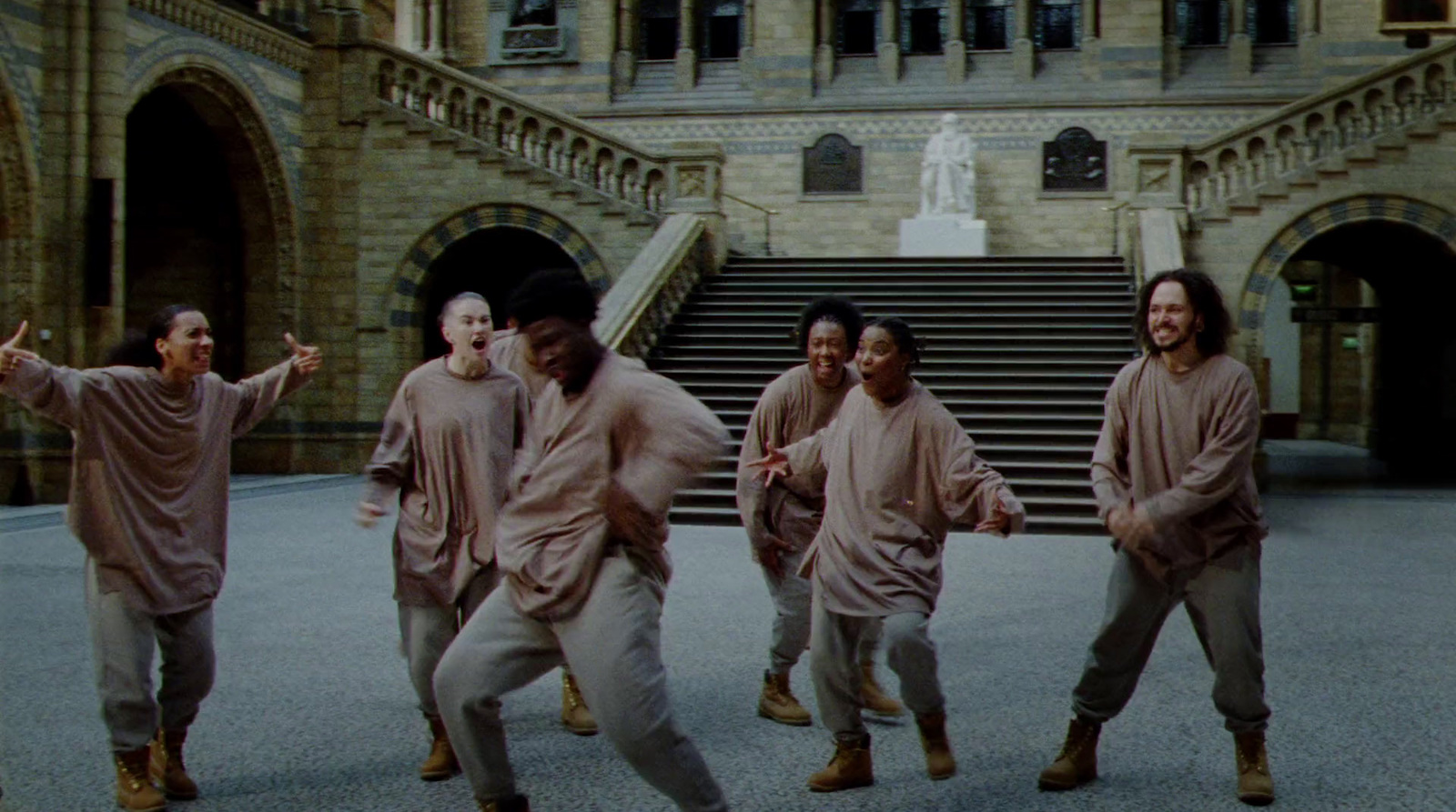 a group of people are dancing in front of a building