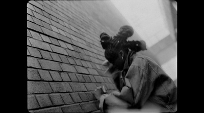 a black and white photo of a person holding a camera