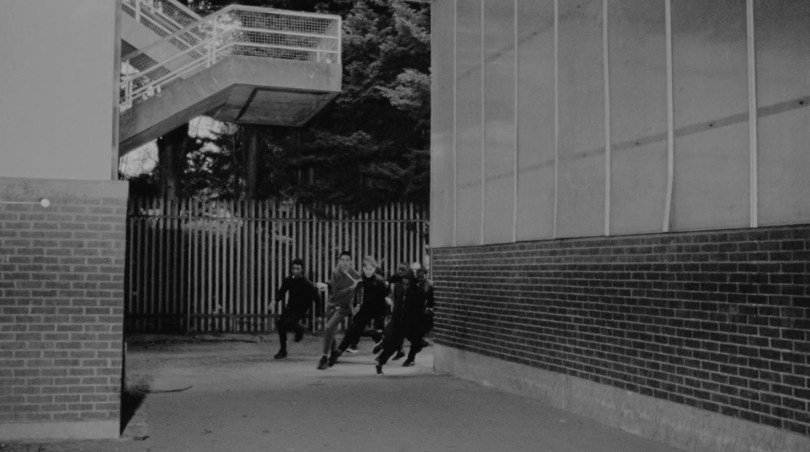 a black and white photo of people walking down a sidewalk