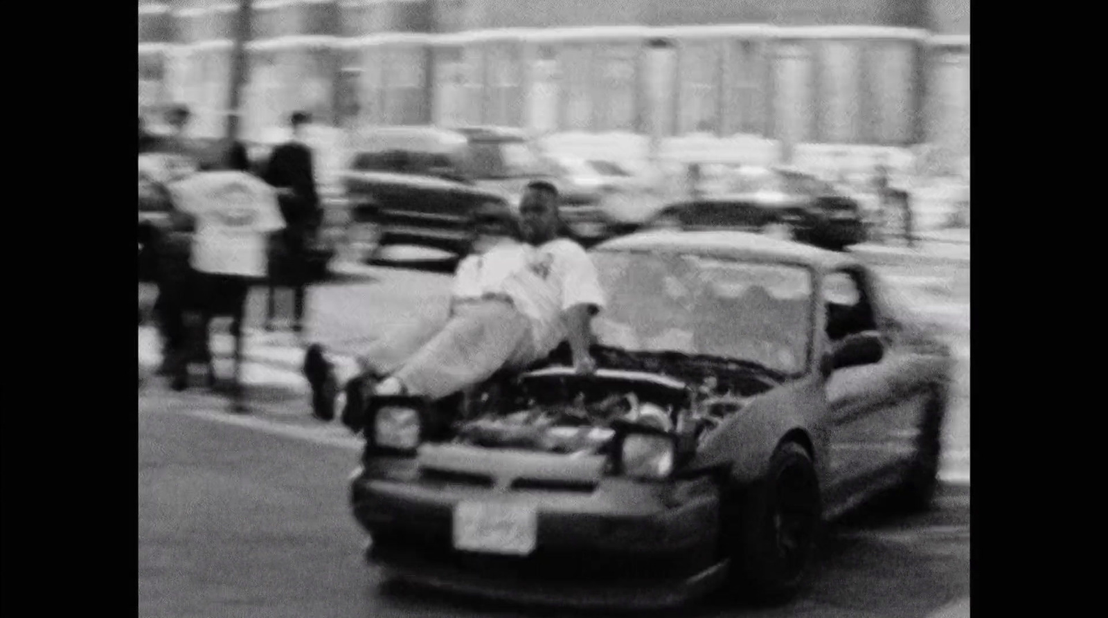 a man sitting on the hood of a car