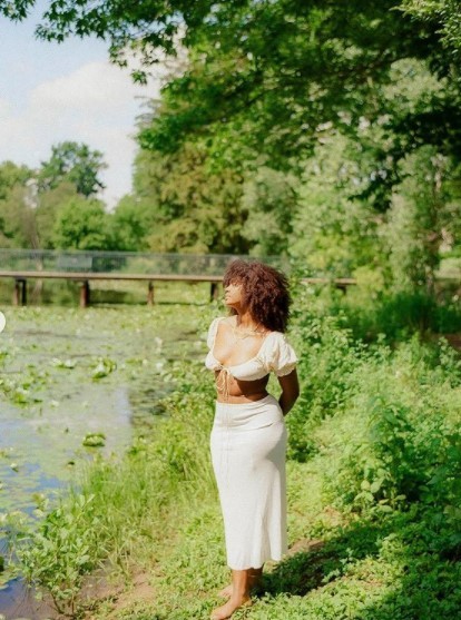 a woman standing next to a body of water