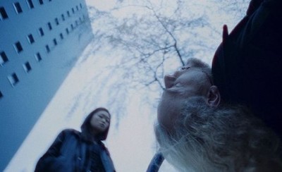 a man and a woman standing in front of a tall building