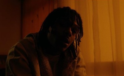 a man with dreadlocks sitting in front of a laptop computer