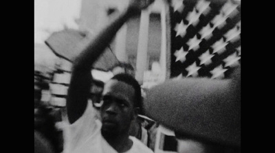 a man holding a tennis racquet in front of an american flag