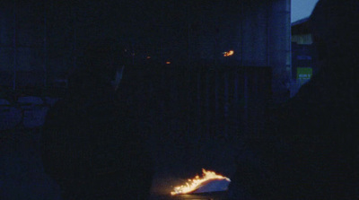 a group of people standing around a fire pit