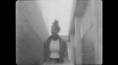 a black and white photo of a person walking down a hallway