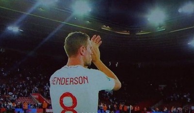 a soccer player is applauding the crowd at a game