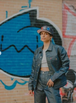 a woman standing in front of a brick wall