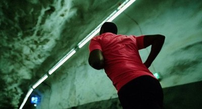 a man in a red shirt is standing in a tunnel