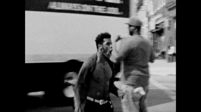 a black and white photo of two men walking down the street