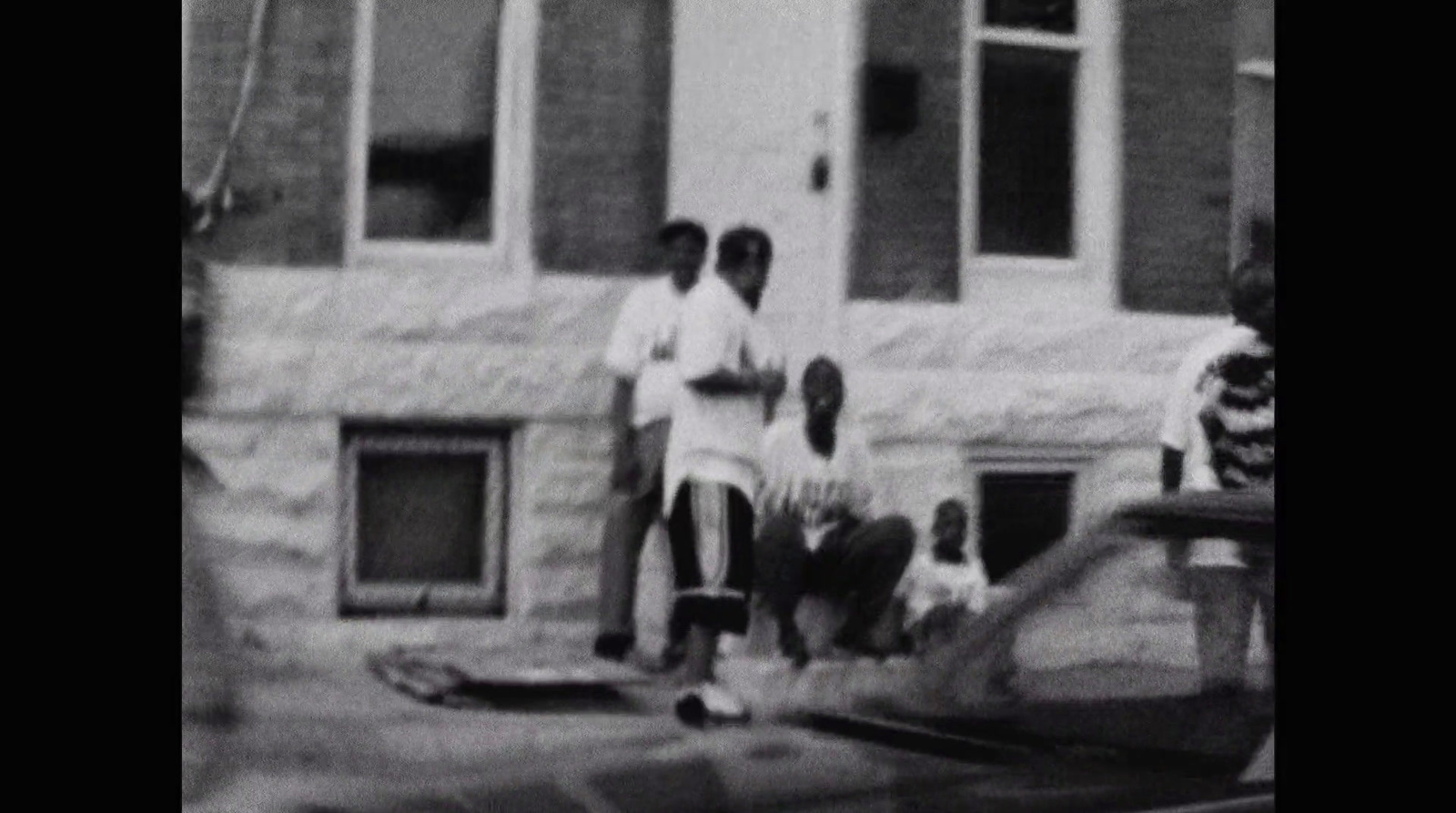 a black and white photo of two men standing in front of a building