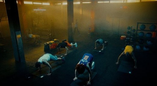 a group of people doing push ups in a gym