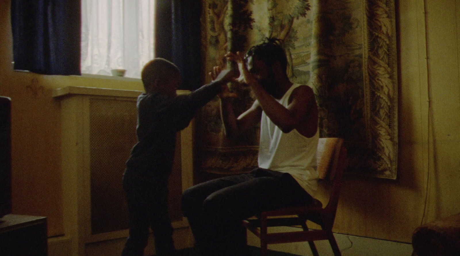 a man sitting in a chair next to a little boy