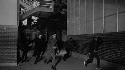 a group of people walking down a sidewalk next to a building