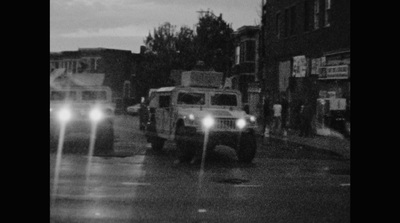 a couple of trucks driving down a street at night