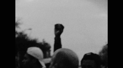 a black and white photo of a person raising their fist