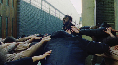 a group of people reaching out of a pile of bags