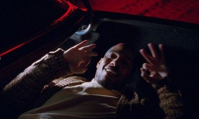 a man sitting in the back of a car with his hands up