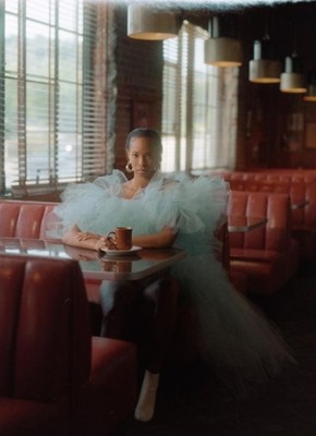 a woman sitting at a table with a cup of coffee