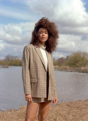 a woman standing in front of a body of water