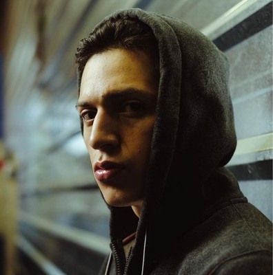 a man in a hoodie looking out a window