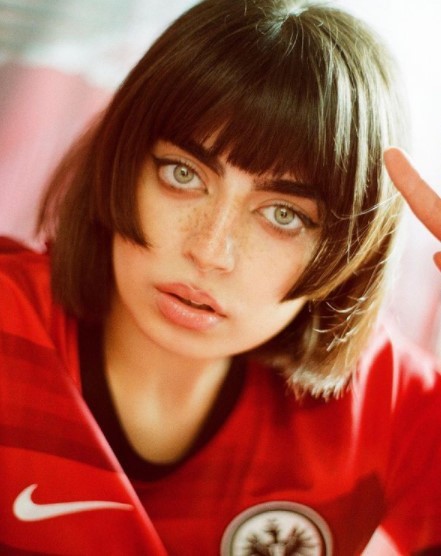 a woman in a red shirt making a hand gesture