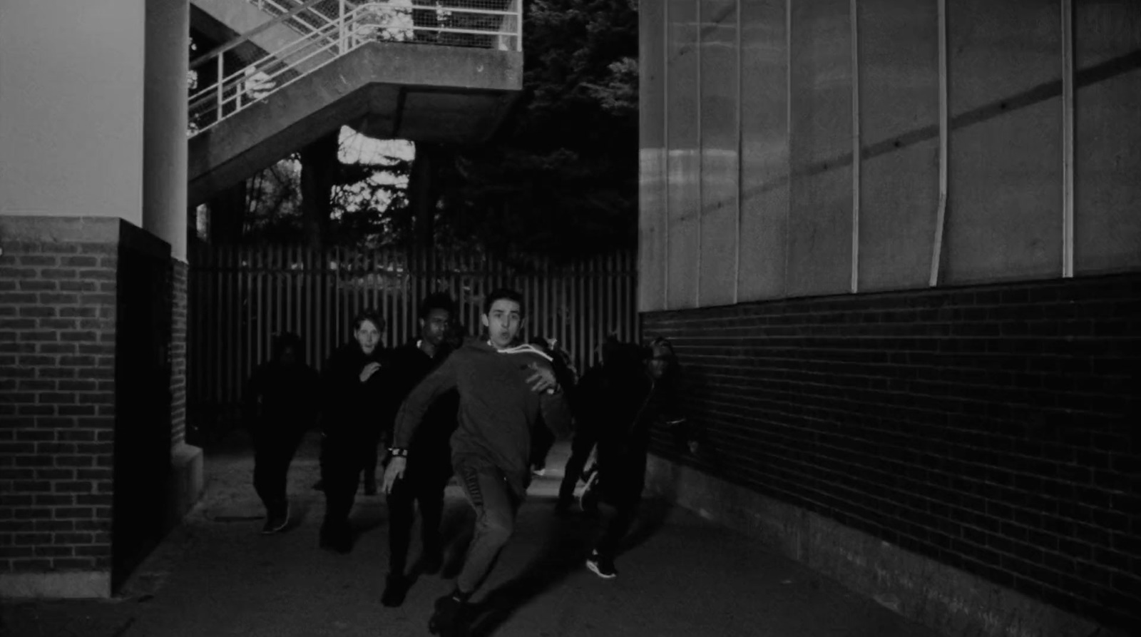 a group of people walking down a sidewalk next to a building