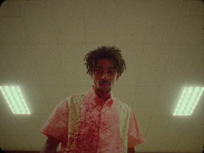 a man in a pink shirt standing in a room