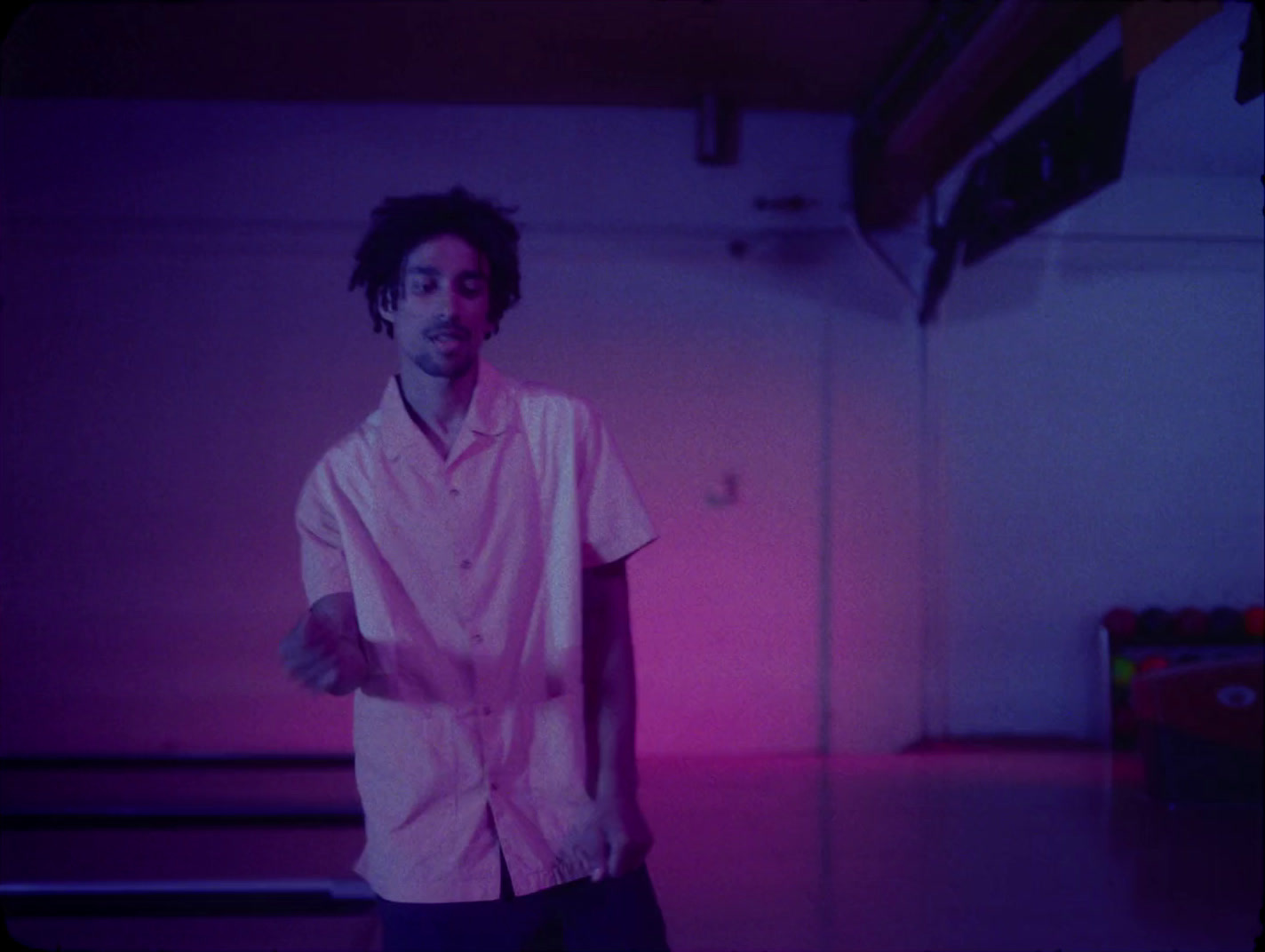 a man in a pink shirt standing in a room