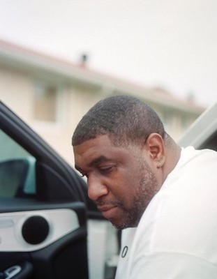 a man sitting in a car looking at his cell phone