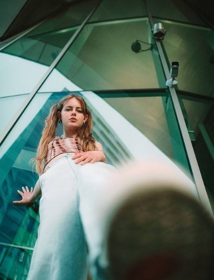 a woman standing in front of a glass building