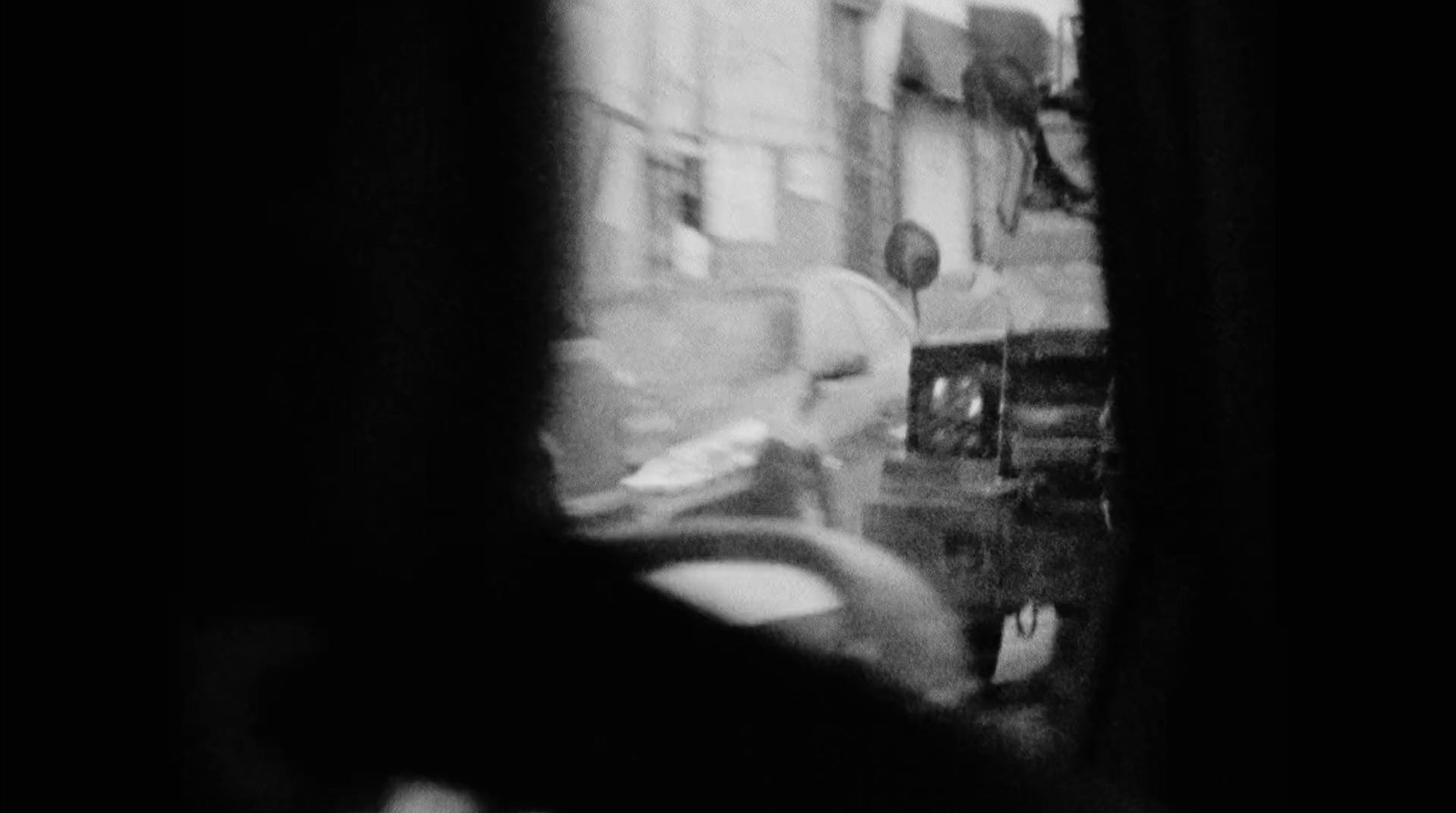 a black and white photo of a person looking out a window