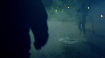 a group of people walking down a street at night