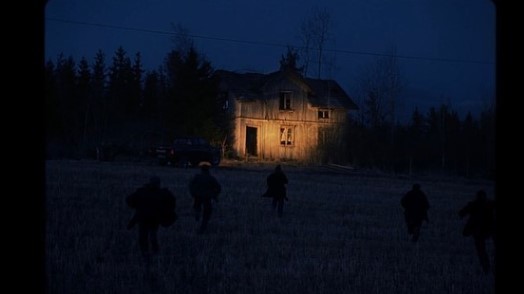 a group of people walking through a field at night