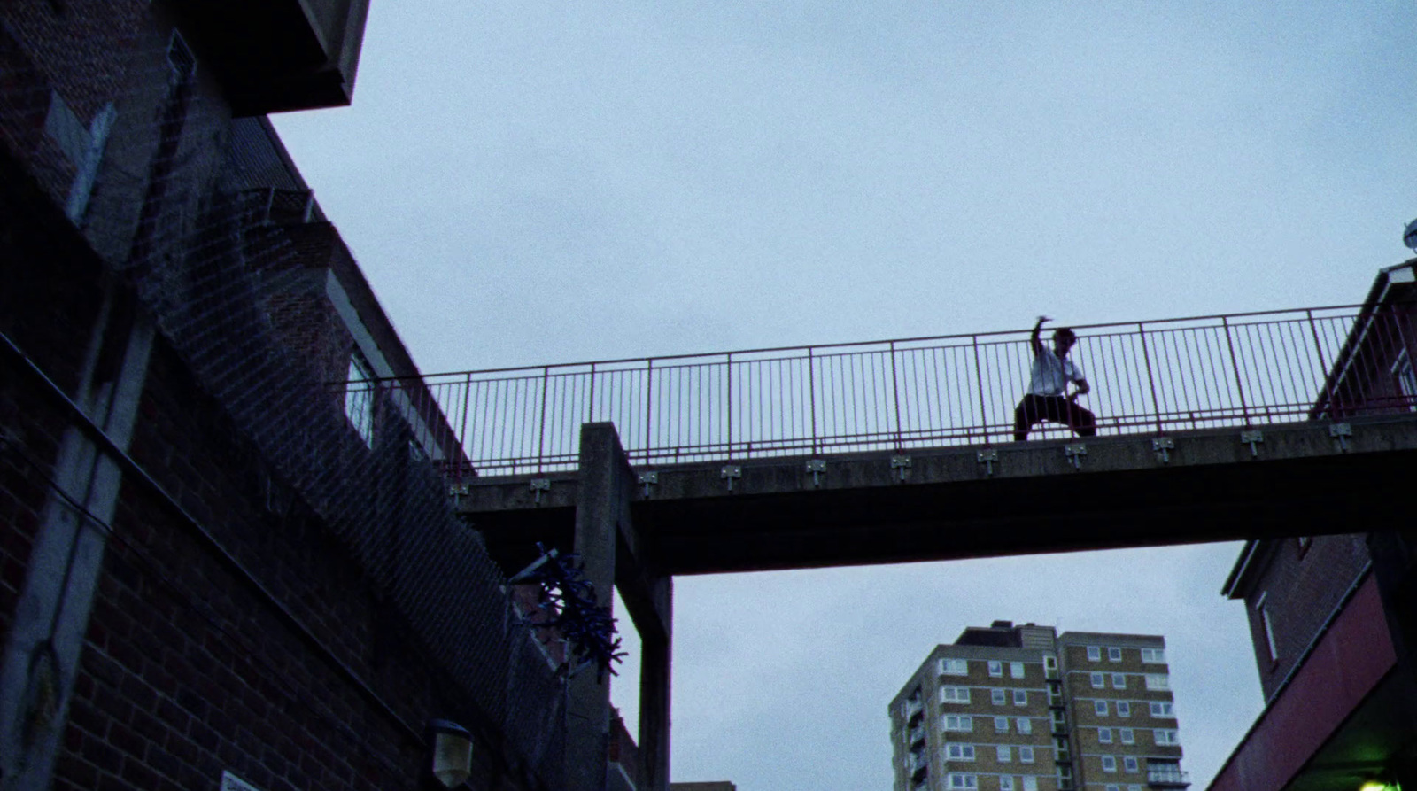 a person walking across a bridge over a street