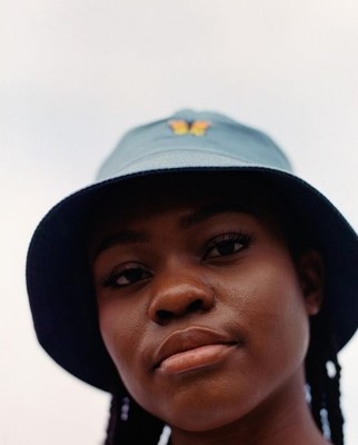 a woman wearing a blue hat with a butterfly on it