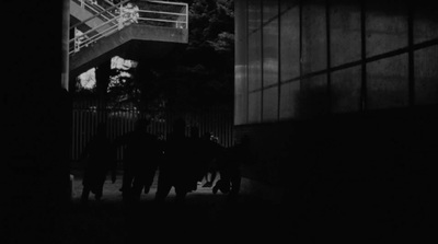 a group of people walking down a street at night