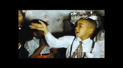 a young boy wearing suspenders and a tie