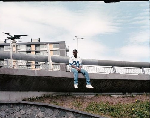 a man sitting on the edge of a bridge