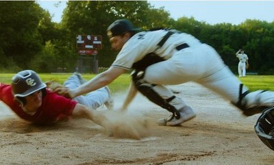 a baseball player sliding into a base while another player tries to tag him out