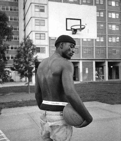 a shirtless man holding a basketball on a basketball court