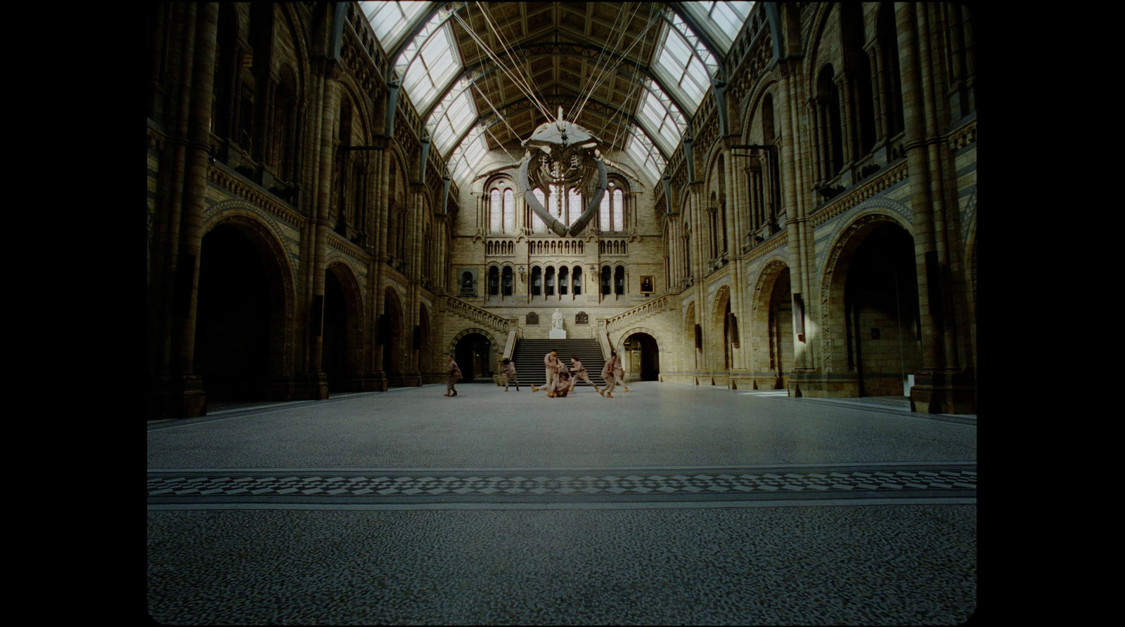 two people sitting on a bench in a large building