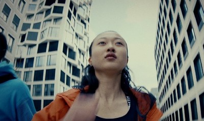 a woman standing in front of tall buildings