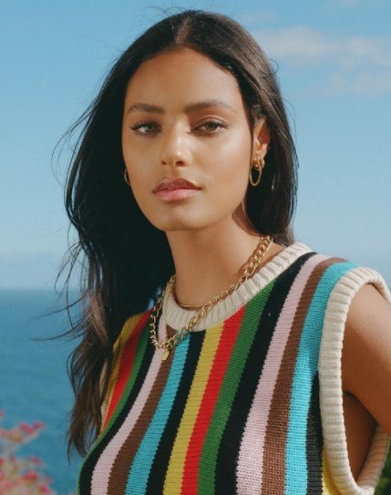 a woman wearing a multicolored striped sweater