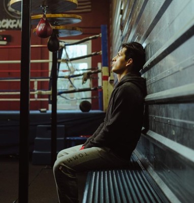 a man sitting on a bench in a boxing ring