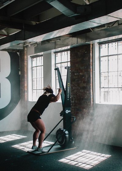 a woman is doing a pull up on a machine