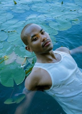 a man is floating in the water with lily pads