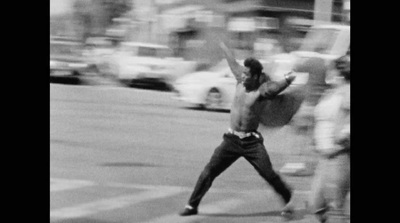 a man holding a tennis racquet on top of a street