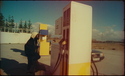 a person standing next to a gas pump